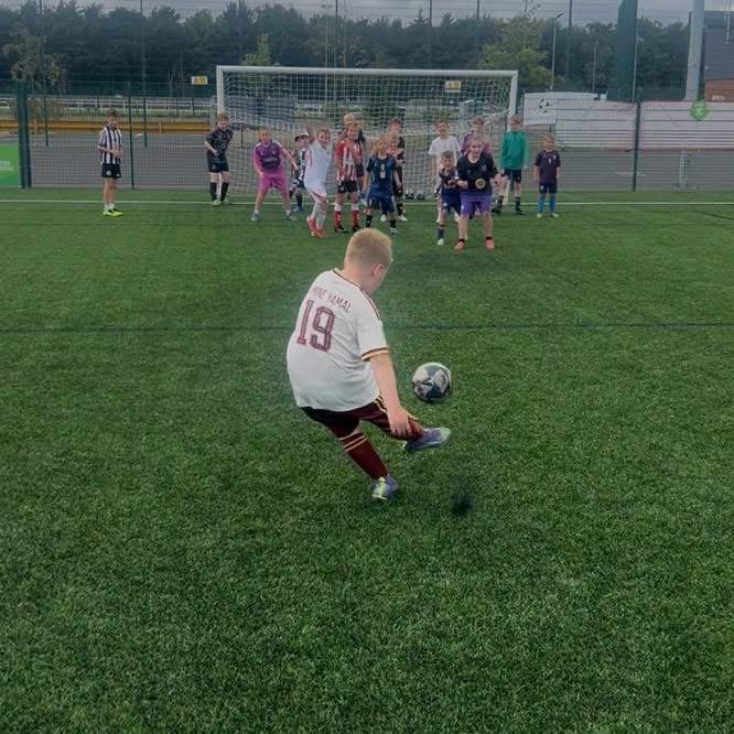 Young footballer enjoying a sunny day at football camp