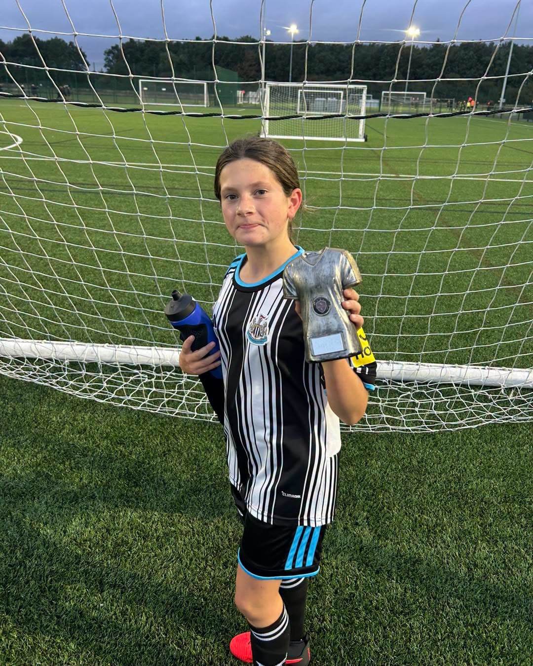 AC Coaching player proudly holding their Player of the Session trophy