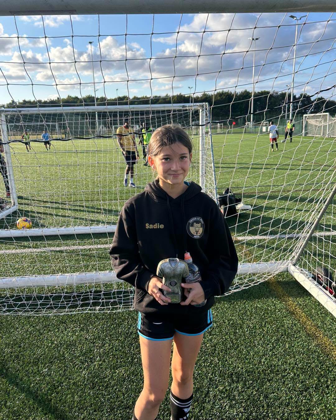 AC Coaching player proudly holding a Player of the Session trophy